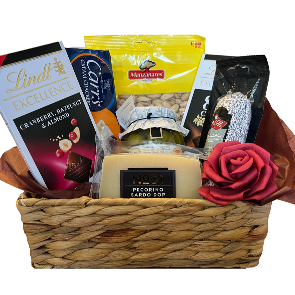 Gift basket with snacks, a bar of soap, and a rose on a white background