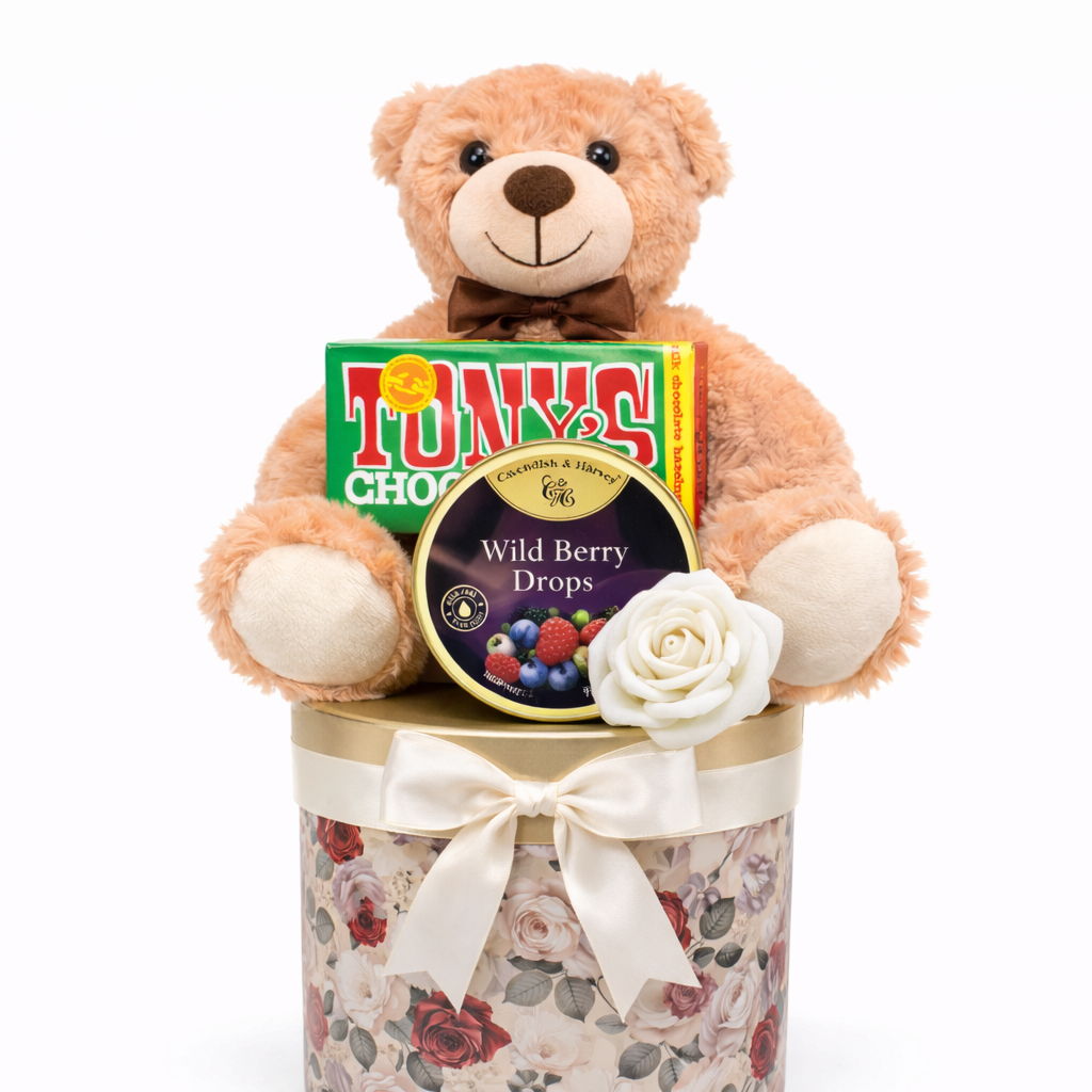 Teddy bear with a floral container holding Tony's Chocolonely chocolate and a white rose on a white background