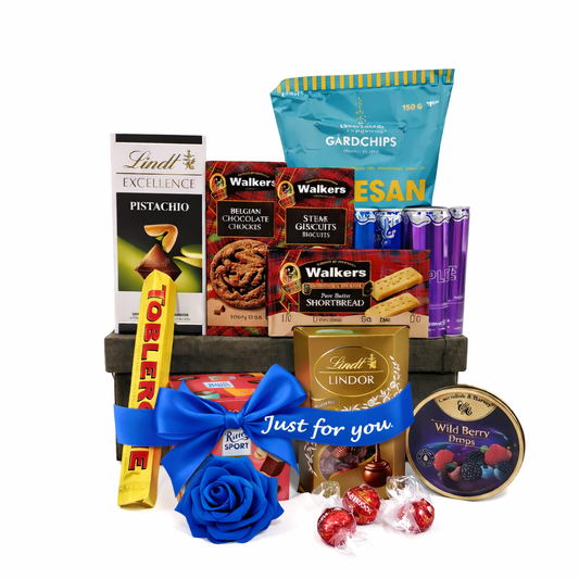 Assorted snacks and candies in a gift basket with a blue bow and 'Just for you' message.